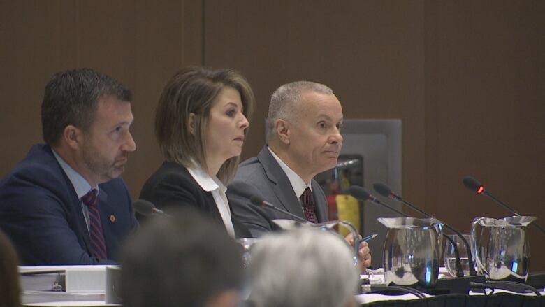 Three N.B. Power executives seated at a table.