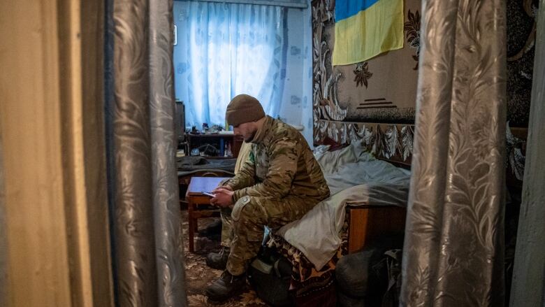 Artillery crew member Denys checks his phone in a house where he and his comrades have been sheltering in Bakhmut, eastern Ukraine. 'The Russians send their soldiers to die,' he said, 'and the Bakhmut battle won't be in their schoolbooks.'