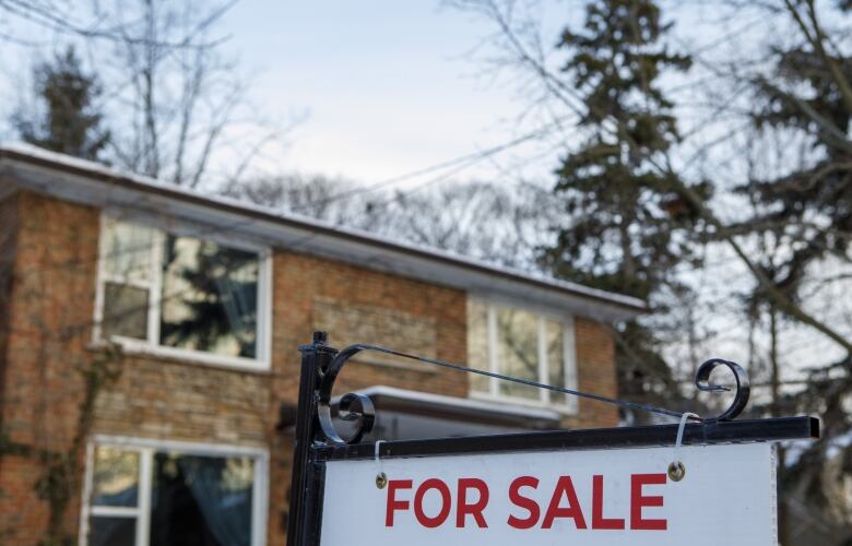 A for sale sign is pictured in front of a home.