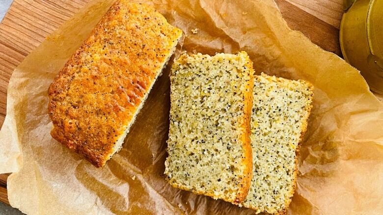 A loaf of lemon poppyseed cake sits on some wax paper.