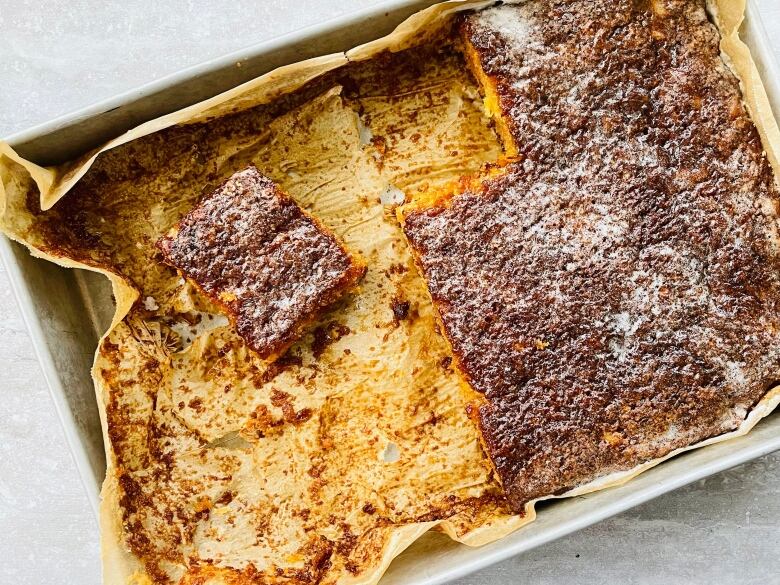 A pan of pineapple cake is half eaten.