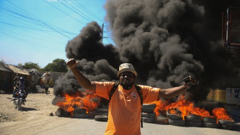 A protester shouts anti-government slogans by a burning barricade set up by members of the police to protest bad police governance in Port-au-Prince, Haiti on Jan. 26, 2023. A wave of grisly killings of police officers by gangs has spurred outrage among Haitians.