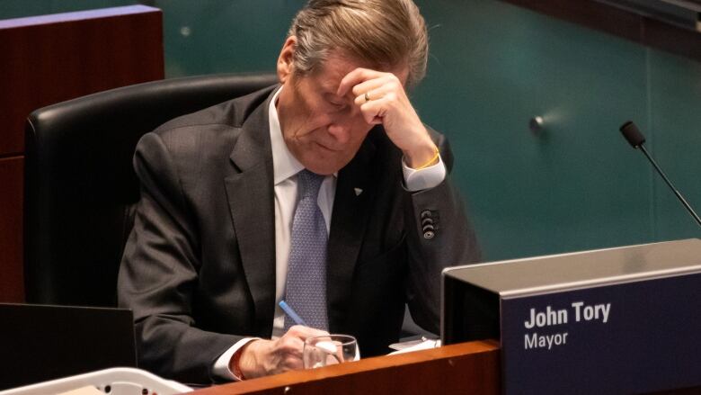 Toronto Mayor John Tory writing at his chambers desk at a Toronto Council Meeting on Feb 15, 2023