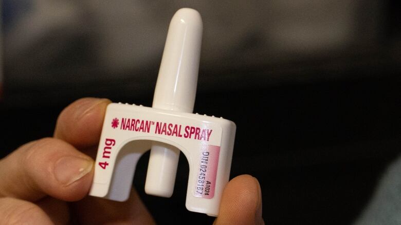 A close up shot of someone holding a nasal spray for opioid overdoses.