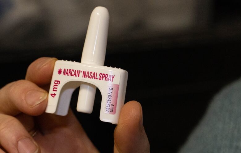 A close up shot of someone holding a nasal spray for opioid overdoses.