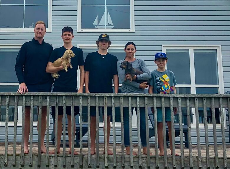 A family of five poses on a deck 