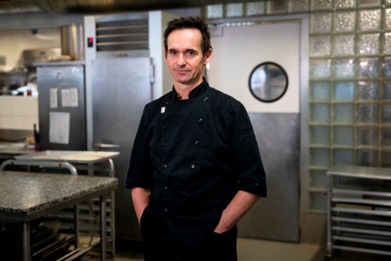 Thomas Haas is pictured in his kitchen in a black bakers outfit. 