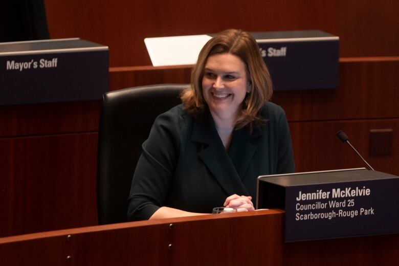 A woman sits at her desk in the city council chamber.