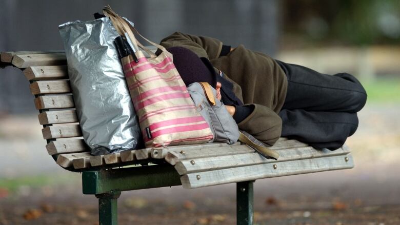 A man sleeps on the bench.