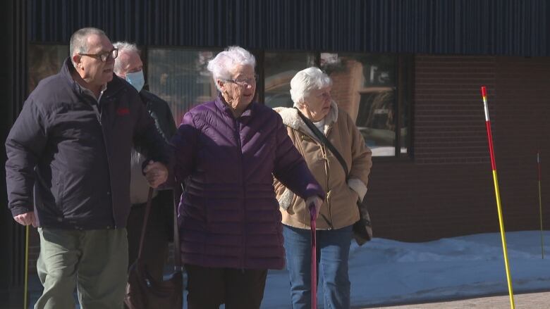 A group of people walking toward a building. 