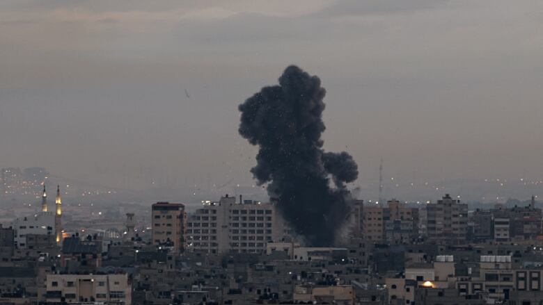 A large plume of black smoke rises from a multi-storey building.