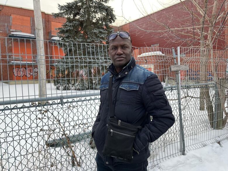 Man standing in front of fence