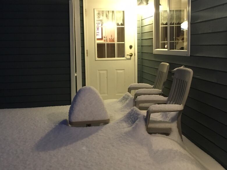 snow piled on a patio and patio furniture