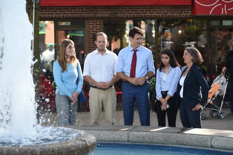 (Left to right) Greektown on the Danforth BIA executive director Mary Fragedakis, Liberal candidate Nathaniel Erskine-Smith, Liberal Leader Justin Trudeau, Noor Samiei, a friend of a victim of the 2018 Danforth shootings, and Julie Dabrusin, Liberal candidate for Toronto-Danforth, chat beside a fountain during election campaigning in Toronto on Sept. 20, 2019.