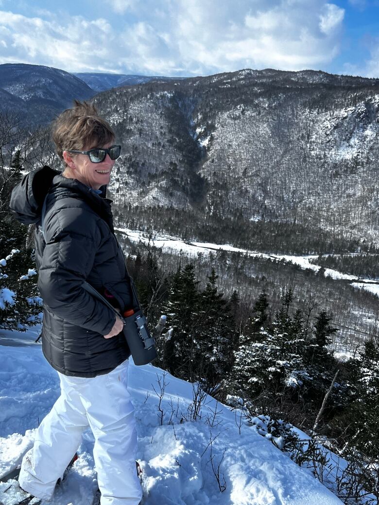 Heather Smith smiles at the camera with a mountain vista in the background.