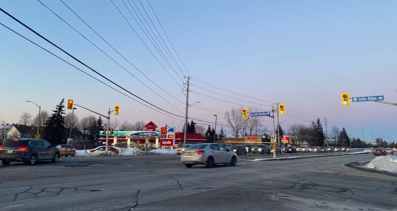 A car drives through a traffic light on Hunt Club Road. 