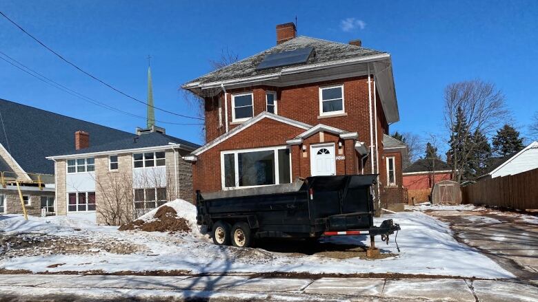 The exterior of the new men's shelter in Summerside, shows a snowy brick building with new fencing. 