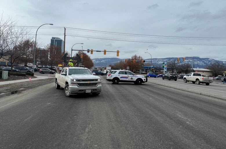 Vehicles, including an RCMP SUV, are seen blocking off a portion of a multi-lane highway.