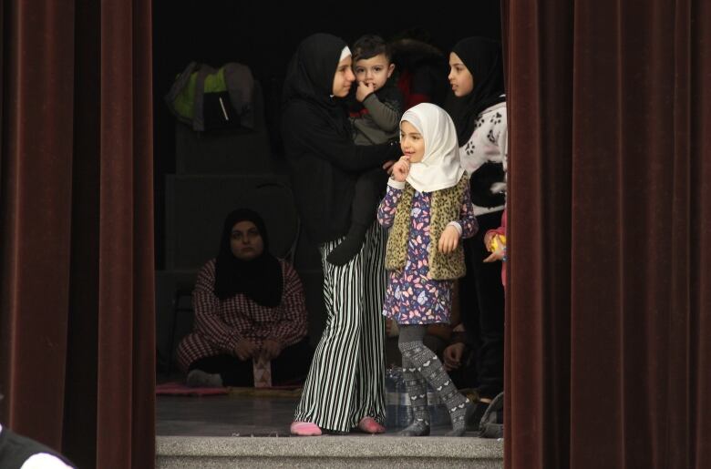 A few youth look out from the stage, before the jumah gets started.