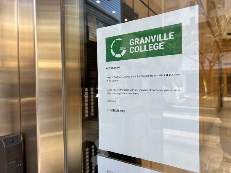 A sign taped to a window outside Granville College outlines COVID-19 protocols.