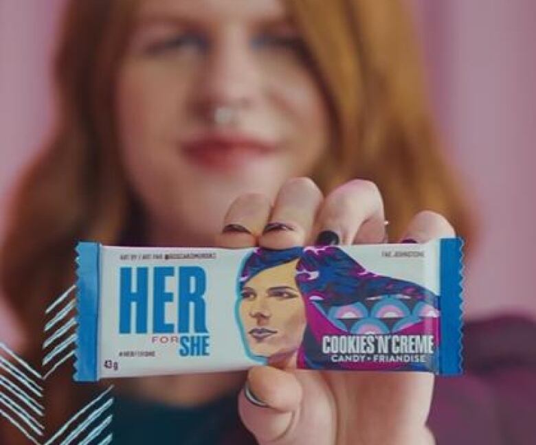 A woman holds up a bar with her image on it.