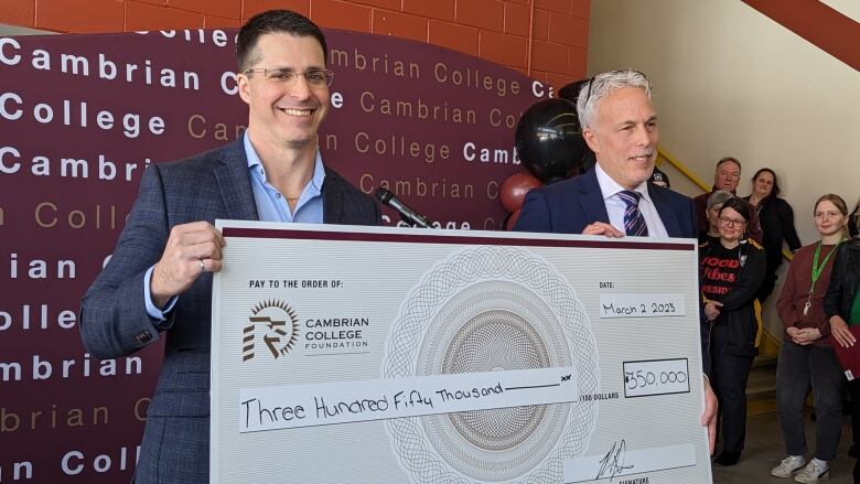 Two men holding a giant cheque.