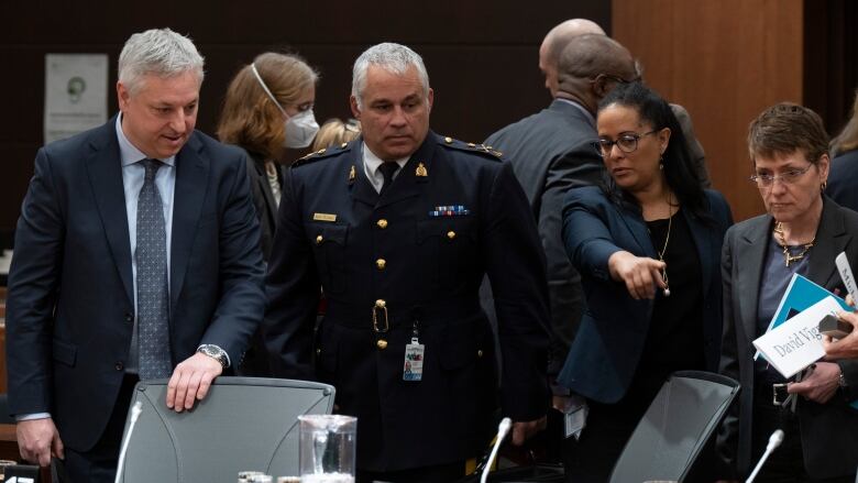 Canadian Security Intelligence Service Director David Vigneault, left to right, Royal Canadian Mounted Police Deputy Commissioner Michael Duheme, Communications Security Establishment Chief Caroline Xavier and Canadian Security Intelligence Service Deputy Director of Operations Michelle Tessier discuss where to sit before appearing at the Procedure and House Affairs committee on Parliament hill, in Ottawa, Thursday, March 2, 2023. 