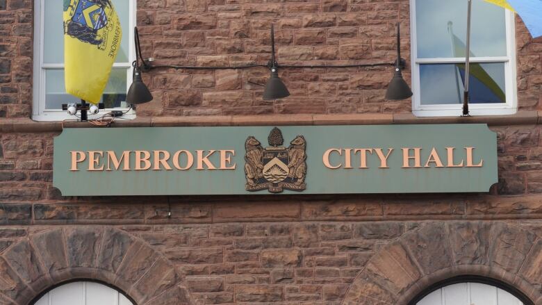 A brown building with a city hall sign.