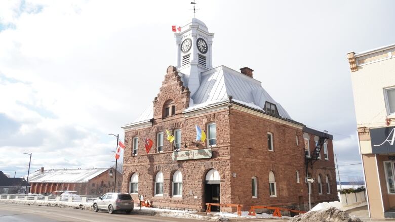 A brown brick building in late winter that houses a small city hall.