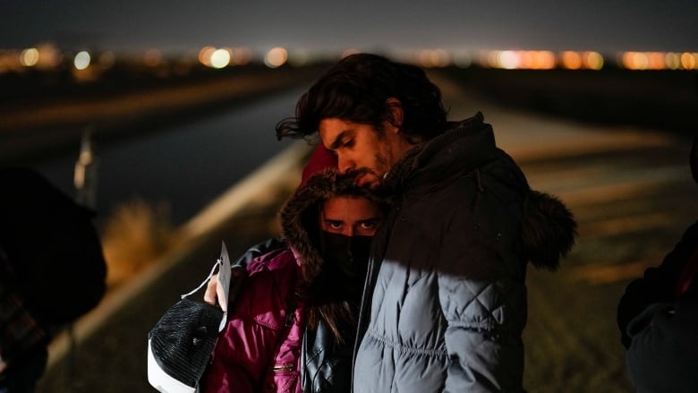 Cuban migrant Mario Perez holds his wife as they wait to be processed to seek asylum after crossing the border into the United States on Jan. 6, 2023, near Yuma, Ariz. U.S. authorities have seen a 97 per cent decline in illegal border crossings by migrants from Cuba, Haiti, Nicaragua and Venezuela since Mexico began accepting those expelled under a pandemic-era order, the Biden administration said Wednesday, Jan. 25, 2023.