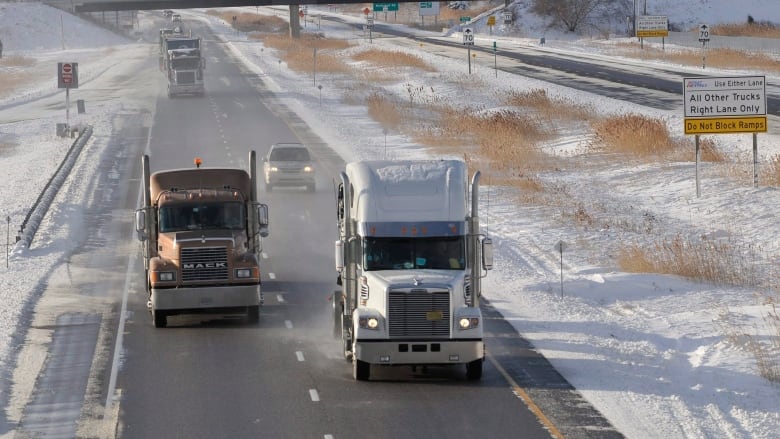 Several trucks run on the highway.