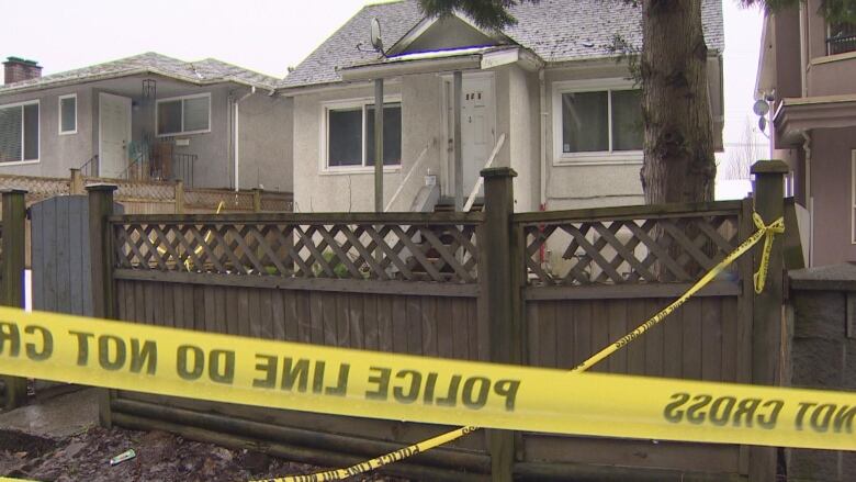 A house is pictured with yellow police tape in the foreground. 