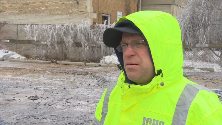 A man in a yellow jacket and glasses.