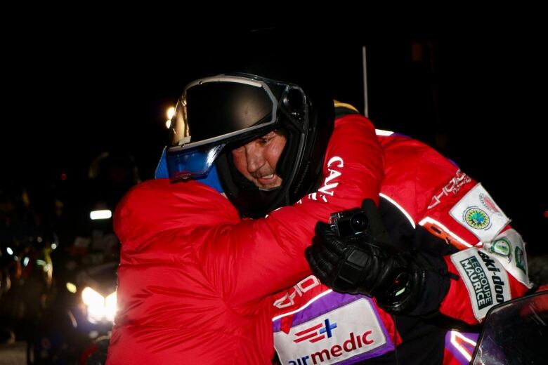 A person hugs someone on a Ski-Doo.