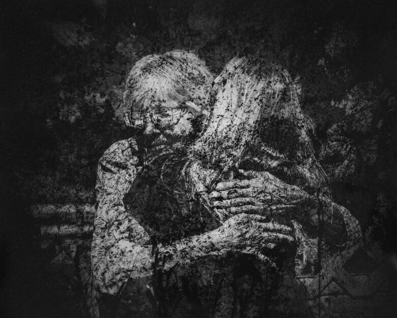 Two people embrace in a dark picture showcasing the unique way the artist decided to render scenes in negative to showcase the dark period in their history.