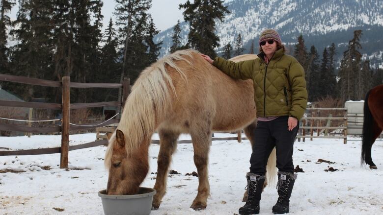 Lisa Young, a board member with the Bow Valley Riding Association, poses with a horse on the association's property.