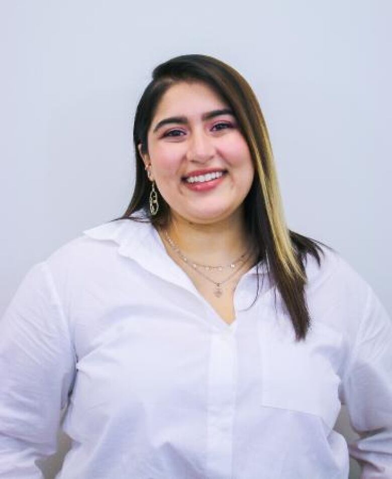 A woman in a white shirt smiles.