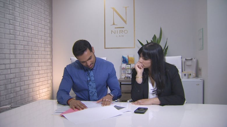 Niroosan Vivekanantharajah, lawyer with Niro Law, sitting in a chair in his office showing reporter Farrah Merali the alleged fraudelent IDs that were used to close the sale of a Scarborough home.