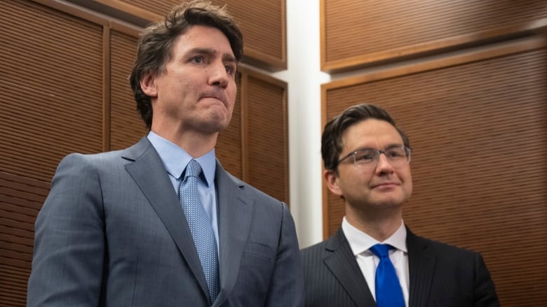 Prime Minister Justin Trudeau stands next to Conservative Leader Pierre Poilievre.