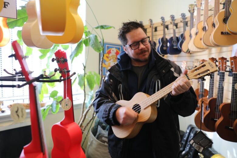 Daniel Hendry plays the ukele at Sawchyn Guitars. 