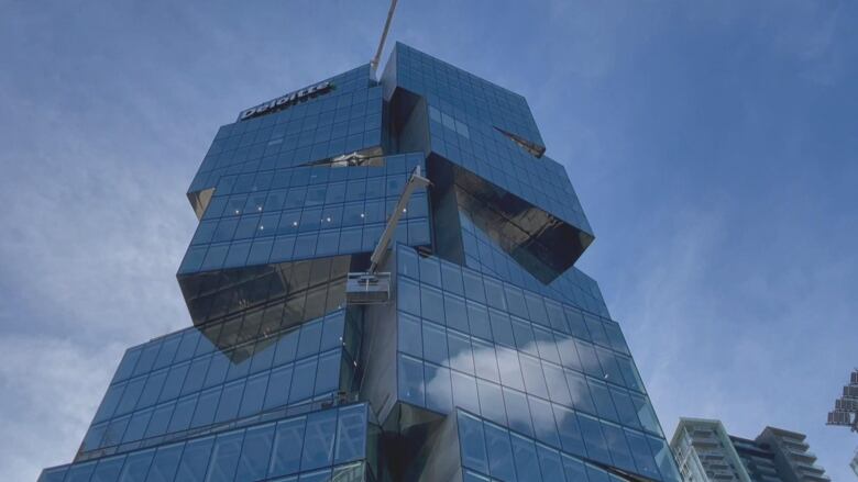 A window cleaners' scaffolding dangles from a skyscraper.