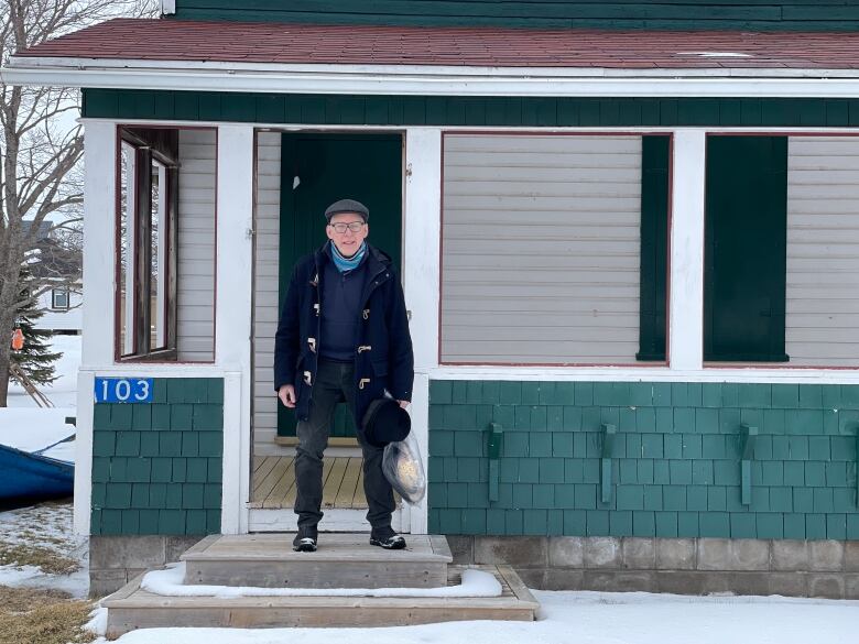 Tim Borlase pictured on the front door step of his green cottage