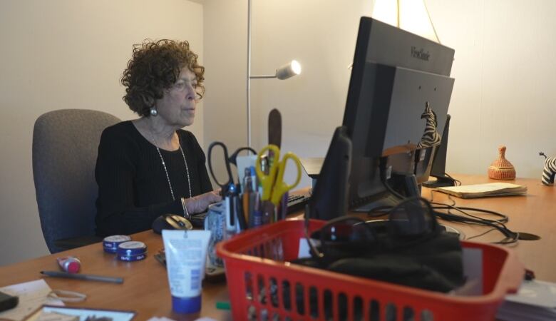 Photo of Martha Friendly sitting at her desk. 