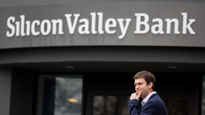 A man stands outside a bank.