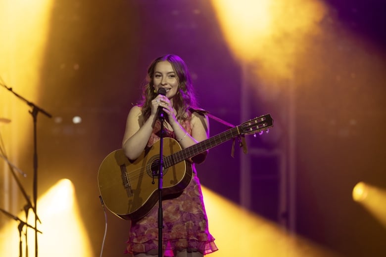 Devon Cole sings with her guitar.