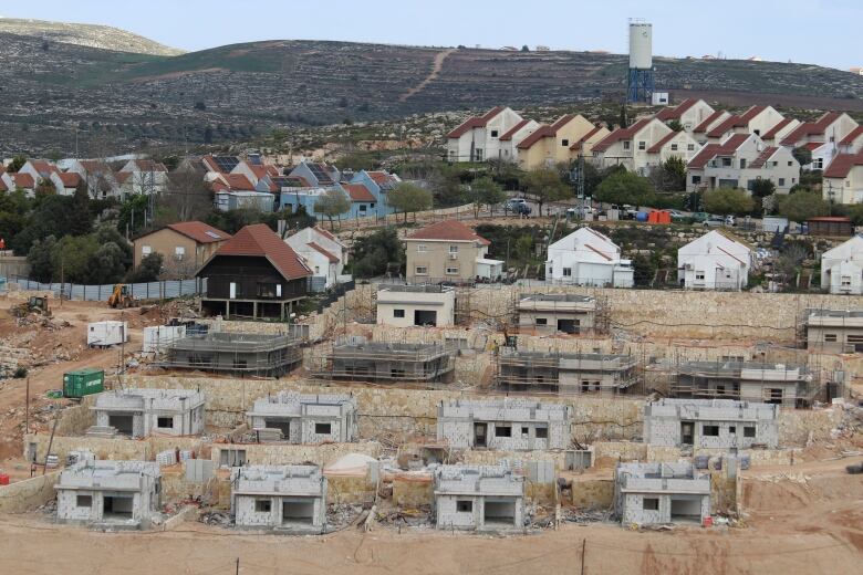 Small houses, some still under construction, line a hill.