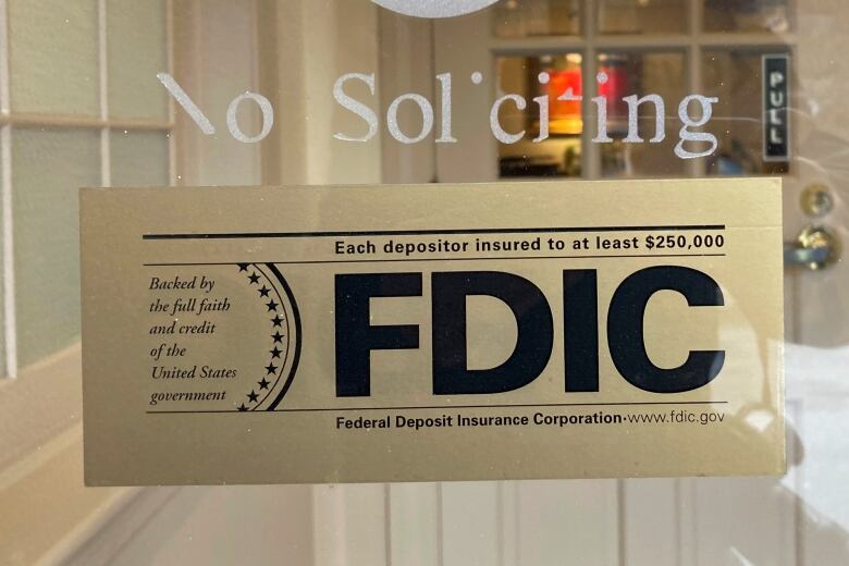 A sign is posted on a window of a bank.