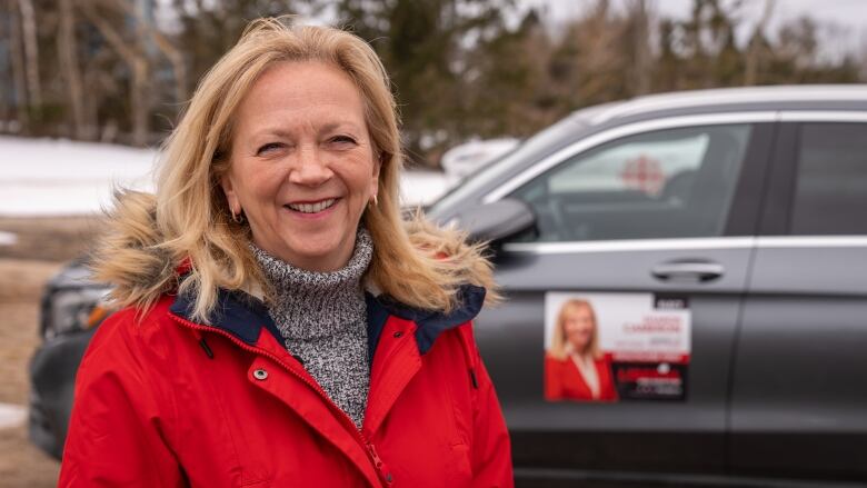 Liberal Leader Sharon Cameron standing in front of her campaign vehicle. 