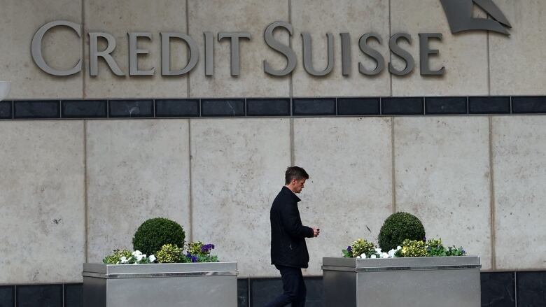 A man walks in front of a bank.