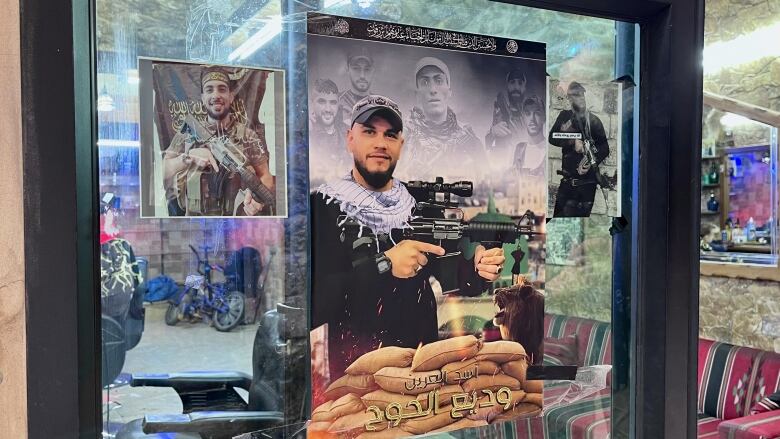 A poster featuring the images of slain members of a militant group are seen on the window of a barber shop.